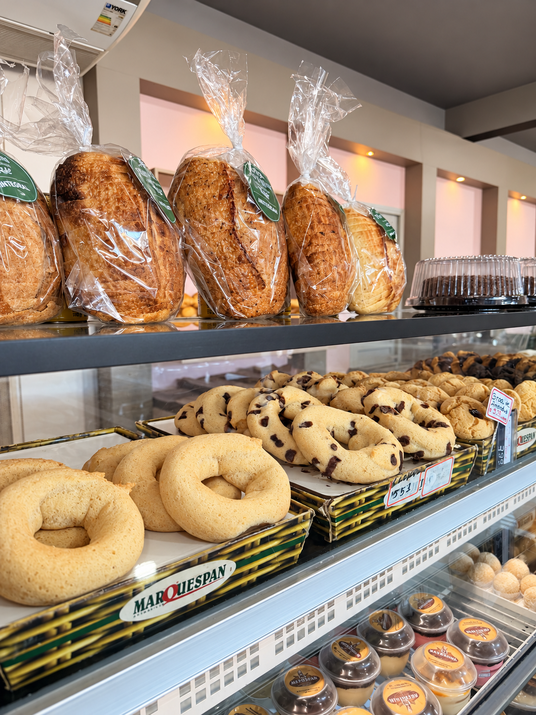 Vitrine da padaria com pães, biscoitos e potinhos de doce